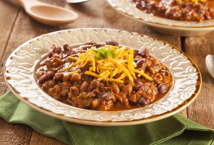 a plate of slow cooker hearty red bean chili topped with shredded cheese