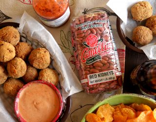 a tray of red beans and rice boudin balls with dipping sauce in a cup on the side, next to a package of camellia brand red kidneys