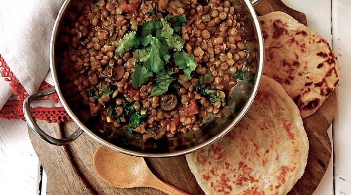 a pot of veggie lentils served with pita bread