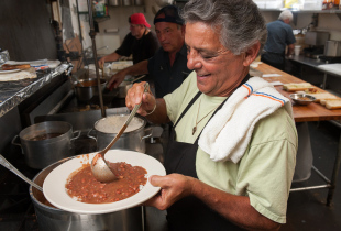 a chef at radosta putting red beans on a plate