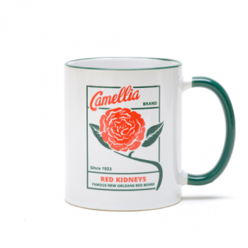 a white and green ceramic mug with camellia logo on it with a flower