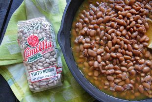 a dutch oven full of pinto beans next to a package of pinto beans