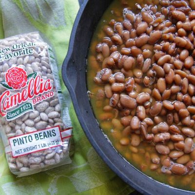 a dutch oven full of pinto beans next to a package of pinto beans