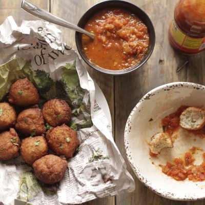 Blackeye Pea Fritters in a basket next to a bowl of salsa for diping