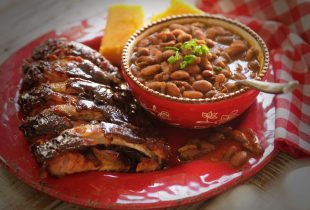 a plate with half a slab of ribs and a side of bbq baked beans