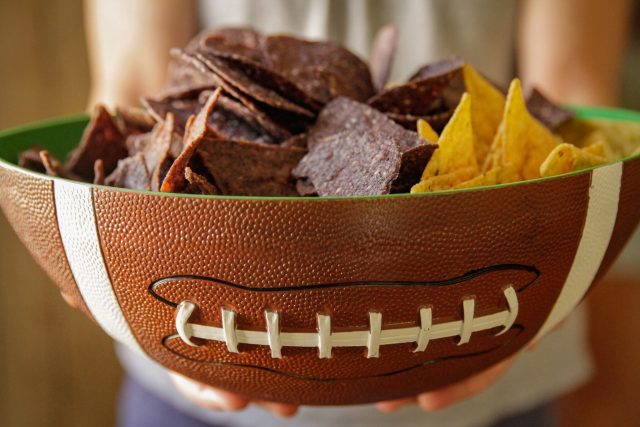 a football shaped bowl full of tortilla chips