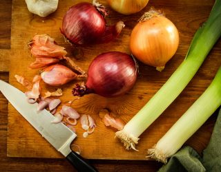 a cut board with a variety of onions