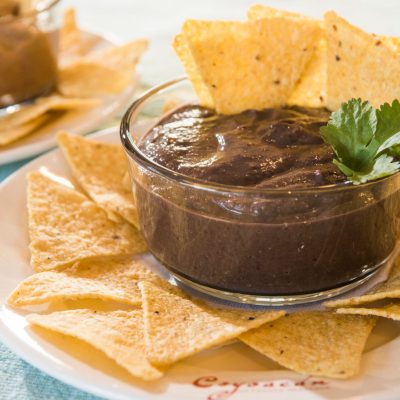 a dipping cup of canal bistro chipotle bean dip with chips