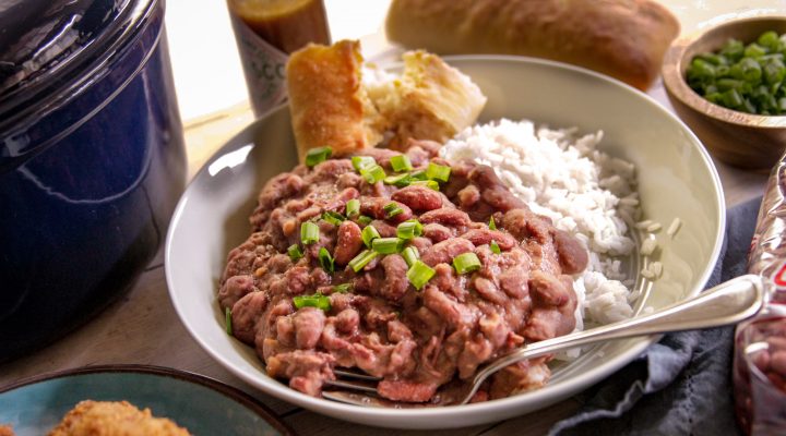 a plate of red beans and rice with a side of corn bread