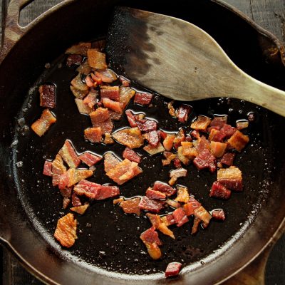 bacon cooking in bacon grease in cast iron skillet