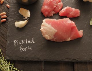 a charcoal cutboard with pickled pork with chalk writting saying pickled pork