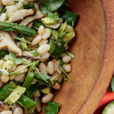 Summer/Spring white bean salad with asparagas and mushrooms in a wooden bowl