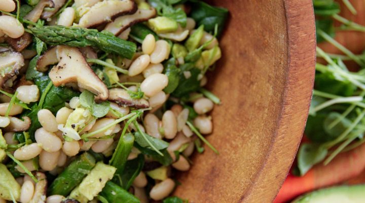 Summer/Spring white bean salad with asparagas and mushrooms in a wooden bowl