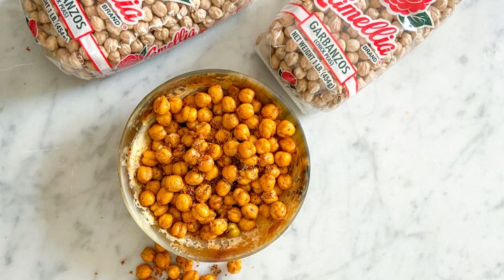 a bowl of texas honey chickpea garganzo with 2 packaged of camellia brand garbanzo beans in the background