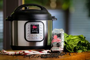 a package of camellia brand black beans next to an instant pot turn on with black beans scattered on the table