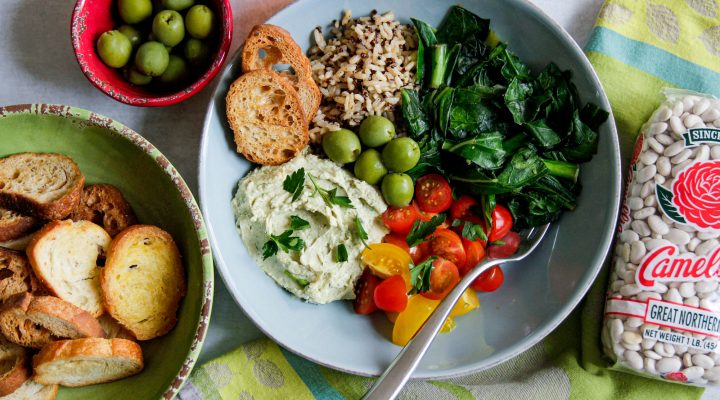 a mediterranean bowl wwith an assortment of meditteranean food in it