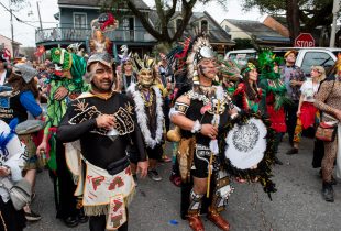 group of people in a Lundi Gras marching parade, costumed