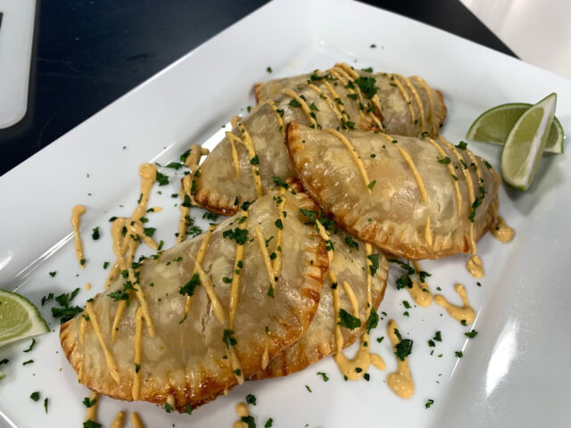 Plate of cooked Pinto Beans and Rajas de Chiles Empanadas with garnishes