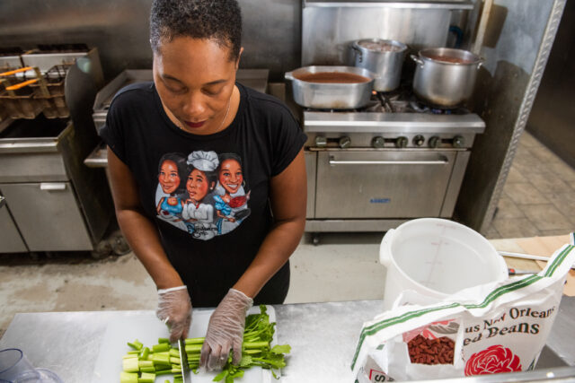 Chopping celery in the kitchen with a bag of Camellia Brand beans