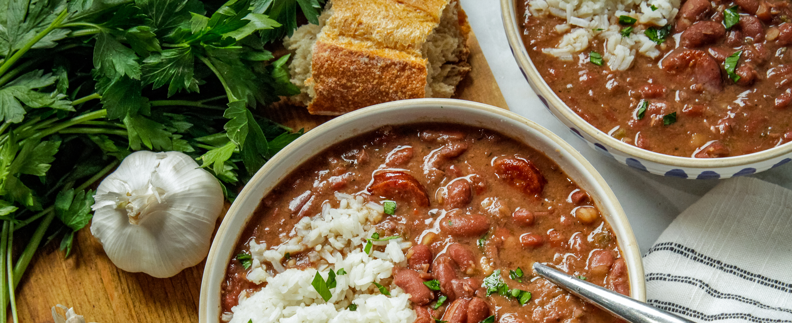 a close up of a bowl of red beans and sausage with garlic